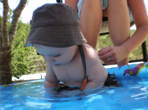 First time in a little pool, with a new hat and bathing suit!